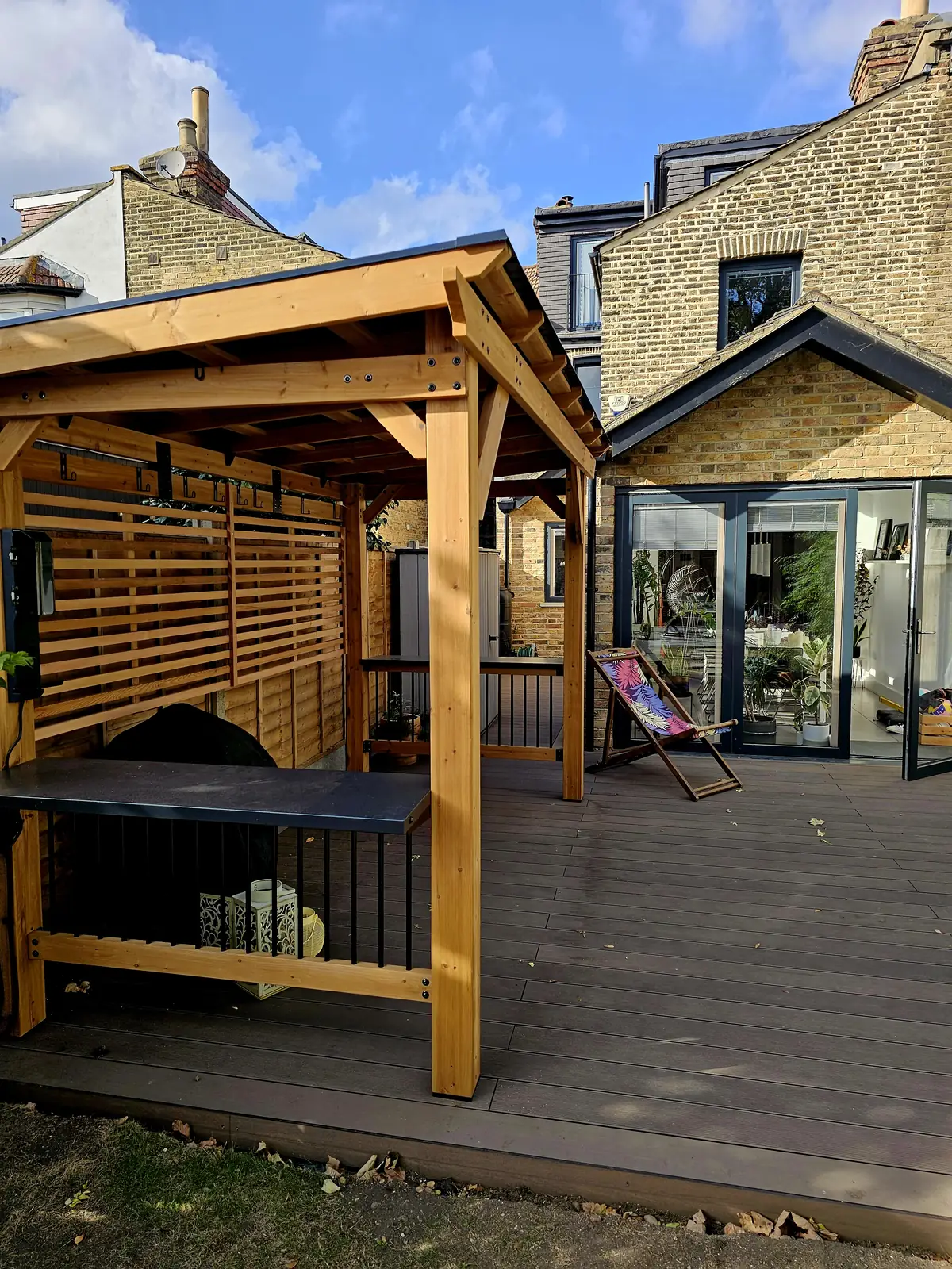 BBQ and bar shelter with a slatted screen and worktop on the new decking