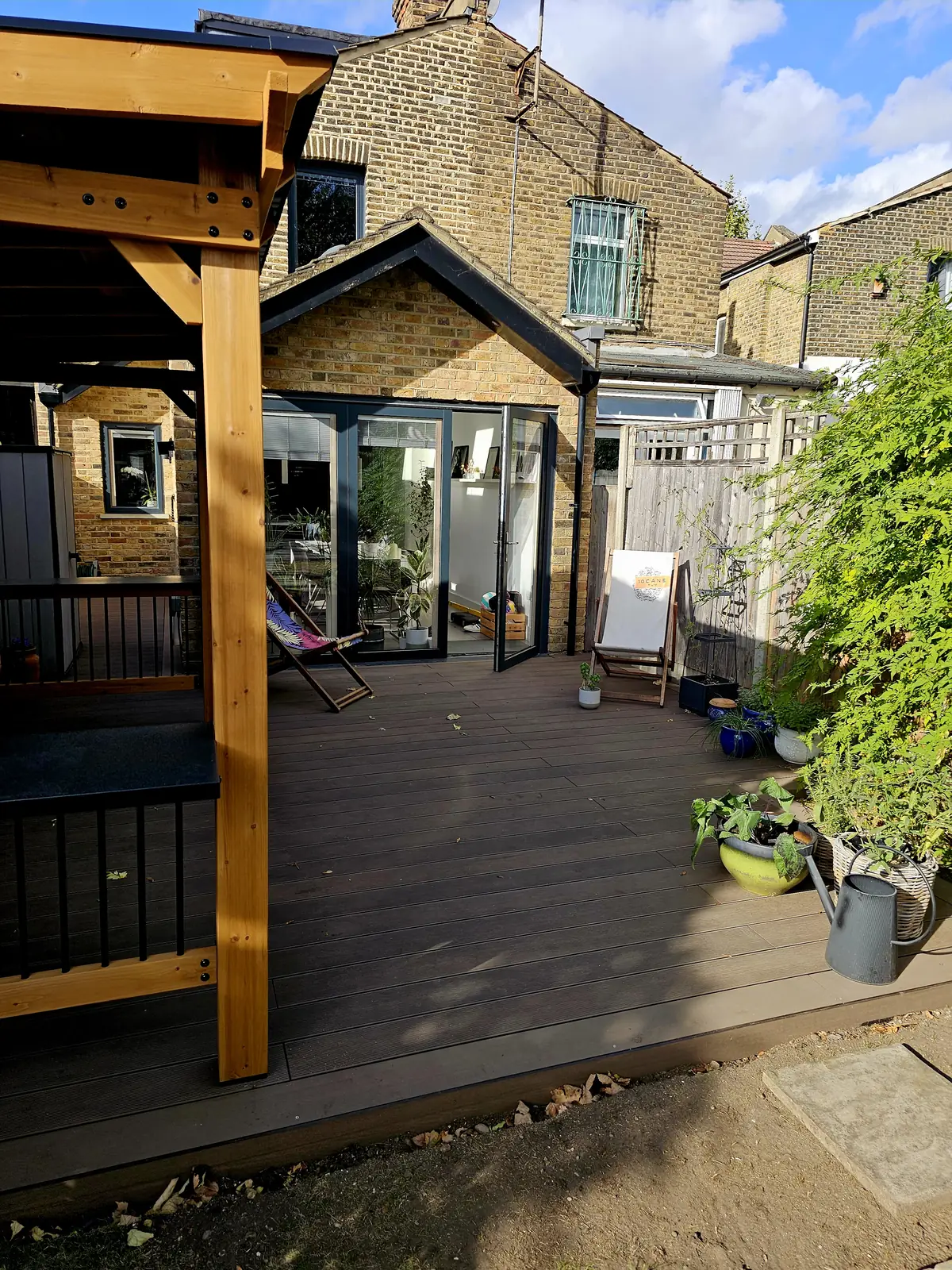 New decking leading to the back of the house, with the BBQ and bar shelter on the left